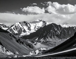 Monochrome mountain range, snow-capped peaks, dramatic shadows, valley below