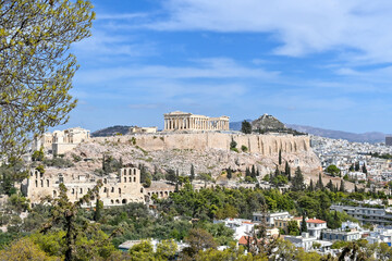 View of the Acropolis at Athens city on a sunny day. Blue cloudy sky at the background.