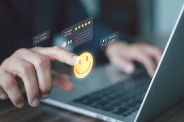 A person is using a laptop and interacting with a digital overlay of a five-star customer review icon, Concept of positive feedback and service excellence. High quality product or services.