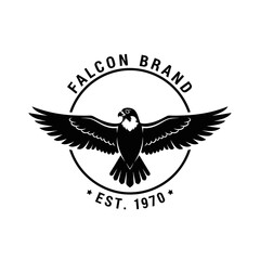 Obraz premium A black and white circular logo featuring a falcon with outstretched wings, with the text 