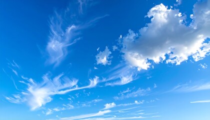 Vivid blue sky canvas adorned with wispy, feathery clouds and a larger cumulus formation
