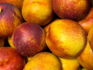 Fresh ripe nectarines close up, yellow and red skin, rich in vitamins and fiber, healthy summer fruit for diet, nutrition, harvest, market and food background concepts.