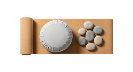 A yoga mat rolled on one side, with a round cushion and smooth river stones arranged on it, isolated on transparent background
