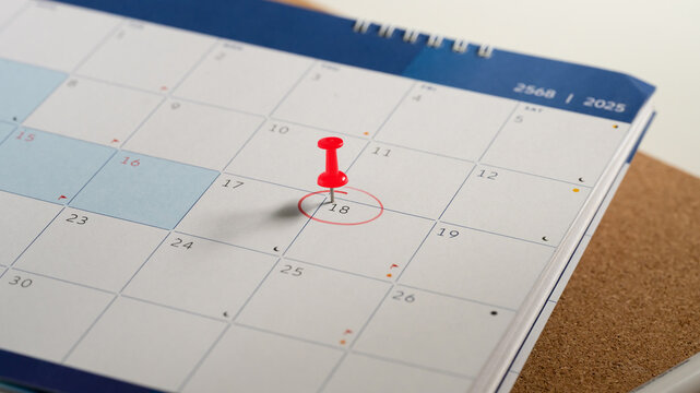 Close up of calendar with the 18th circled in red and red push pin, symbolizing an important appointment - Powered by Adobe