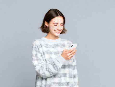Young woman smiling while using facial recognition technology on smartphone for secure access with digital grid on face