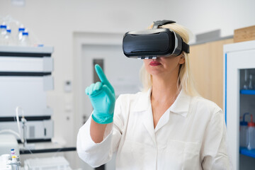 Female researcher wearing VR headset in a high tech chemical lab, performing virtual experiment simulation. Concept of augmented reality in science, digital data visualization, and innovative research