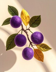 Felted plums, branch, and leaves on cream surface