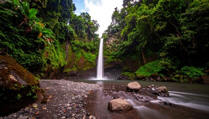 Lush waterfall cascading into a tranquil pool surrounded by dense jungle