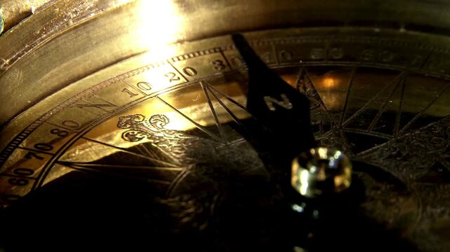 closeup of old style gold compass. Retro styled golden compass and old white nautical chart close-up. Vintage still life. Sailing accessories. Travel, navigation, history, collecting, hobby.