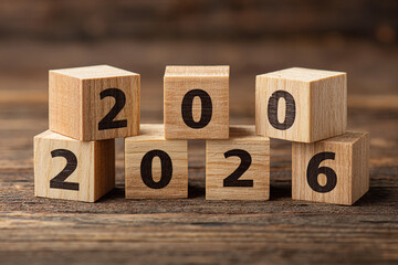 Wooden blocks with black numbers are arranged on a rustic wood surface to display the upcoming year two thousand twenty-six a concept for new beginnings and future planning