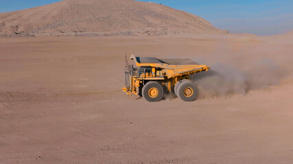 A huge 350 ton mining truck awaits the transport of minerals from the open pit mine to the pads