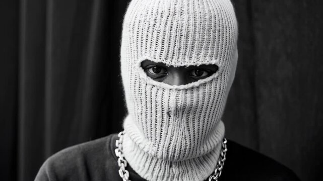 Black‑and‑white portrait of a person in a ribbed ski mask, eyes framed by soft window light&mdash;moody, editorial character piece designed for fashion edits, music visuals and urban narratives exploring st