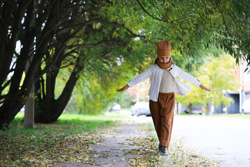 Child Strolling Through Autumn Leaves in Stylish Outfit Under Tree Canopy