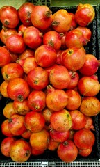 Red pomegranates on the counter in the store, Autumn pomegranate season, market sales concept, advertising and PR.