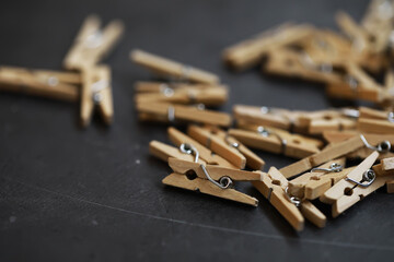 Close-Up View of Wooden Clothespins Scattered on Dark Surface in Minimalist Style