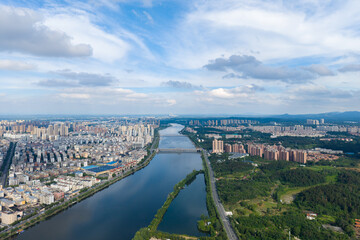 Fototapeta premium Suizhou City vista shows urban buildings along water and green landscapes.