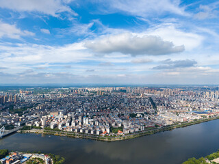 Fototapeta premium Suizhou City Hubei Province China cityscape spreads across the horizon under a cloudy blue sky showcasing buildings and a river.