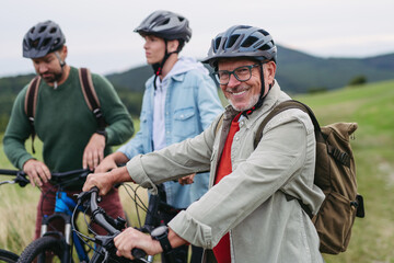 Grandfather, father and teen boy on cycling trip taking selfie.