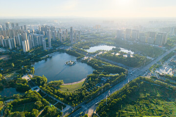 Suizhou City Hubei Province China shows city buildings and lakes surrounded by green parkland stretching towards the horizon under soft sunlight.