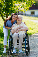 Home nurse taking care of elderly woman in wheelchair.