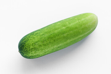 Closeup shot of a green cucumber, showcasing its natural texture. The vegetable is placed against a clean white background. Ideal for themes related to healthy eating, ingredients, or fresh produce.