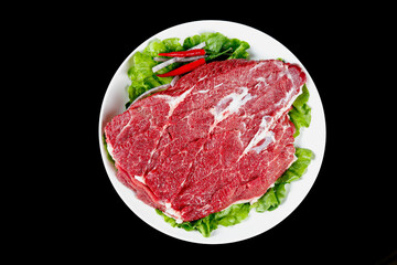 Fresh Raw Beef Brisket Slices on White Plate with Lettuce Garnish