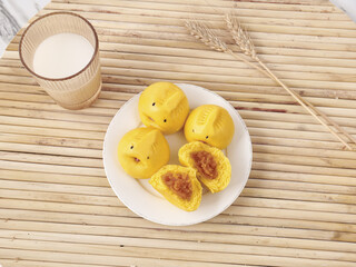 Yellow Steamed Buns with Red Bean Filling Asian Snacks on Bamboo Mat