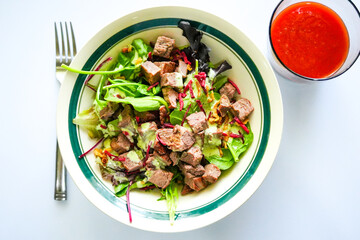Refreshing cold steak salad, loaded with greens, shredded beets, and creamy dressing—served alongside a bold glass of fresh tomato juice for a nutrient-rich bite.