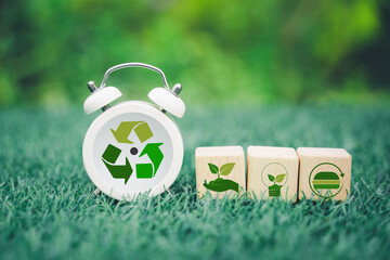 wooden cube block and white clock with recycle icon on blurred green nature background for Reduction of carbon emissions, carbon neutral concept. Net zero greenhouse gas emissions target