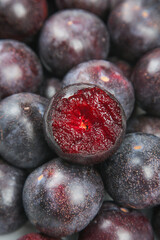 Fresh Red Plums Cut in Half Showing Juicy Interior - Organic Stone Fruit