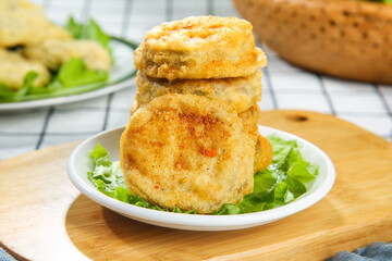 Stack of Golden Deep Fried Eggplant Slices on Lettuce Bed - Crispy Vegetarian Appetizer