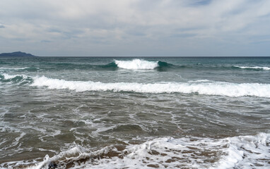 Foamy waves of the cold Atlantic Ocean roll onto the shore near Donostia San Sebastian