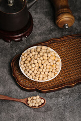 Dried chickpeas in bowl on wooden tray with traditional kitchen utensils for healthy cooking