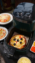 Delicious Italian Pizza with Cheese and Olives Cooking in Air Fryer Kitchen Appliance