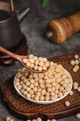 Raw Soybeans in Wooden Spoon and Bowl on Rustic Kitchen Counter
