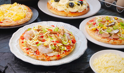 Tantalizingly delicious Italian pizza variety with grilled vegetables, cheese and meat toppings on white plates