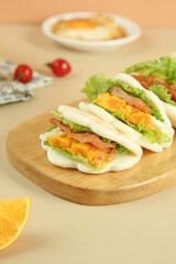 Breakfast Sandwich with Scrambled Eggs Bacon and Lettuce on White Buns Wooden Board Morning Meal