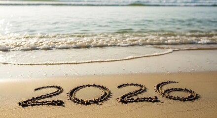 New year 2026 written in sand on a tropical beach with gentle waves
