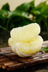 Heart-shaped white pomelo segments on bamboo mat - fresh Thai tropical citrus fruit