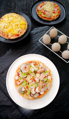 Homemade Italian Pizzas with Seafood Ham and Cheese Toppings on Rustic Wooden Table