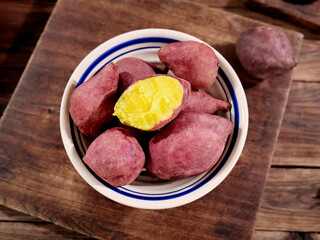 Fresh Purple Sweet Potatoes with Yellow Flesh on Rustic Wooden Board - Healthy Natural Food Ingredients
