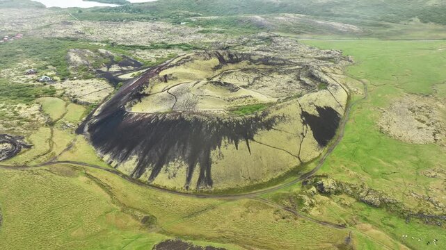 Aerial top down of grabrok crater volcano in idyllic green landscape of Iceland. Peaceful and natural shot of erupted volcano.