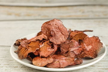 Dried Porcini Mushrooms on White Plate - Premium Cooking Ingredients on Rustic Wood Background