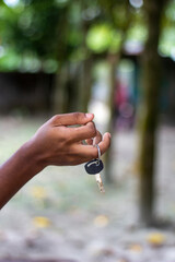 Hand holding a car key with a black fob