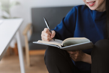 Woman writing in notebook planning studies