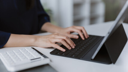 Woman typing on tablet keyboard working remotely