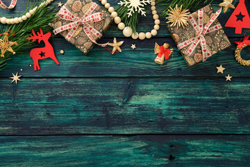 Festive Christmas flat lay composition with pinecone gifts, red ornaments, stars, and pine branches...