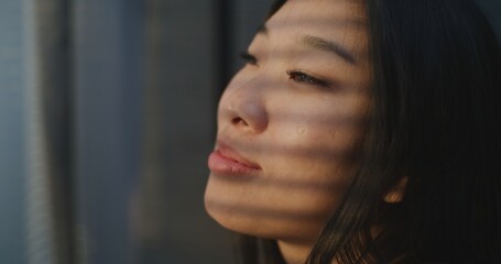 Beautiful Girl Wakes Up in Morning in Bright Bedroom. Young Woman Enjoys Warm Sunshine Falling on...