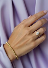 Elegant hand showcasing jewelry against a soft lavender background