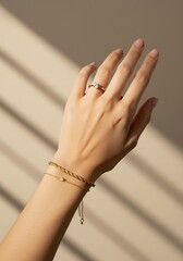 Elegant hand wearing jewelry against a neutral background product showcase